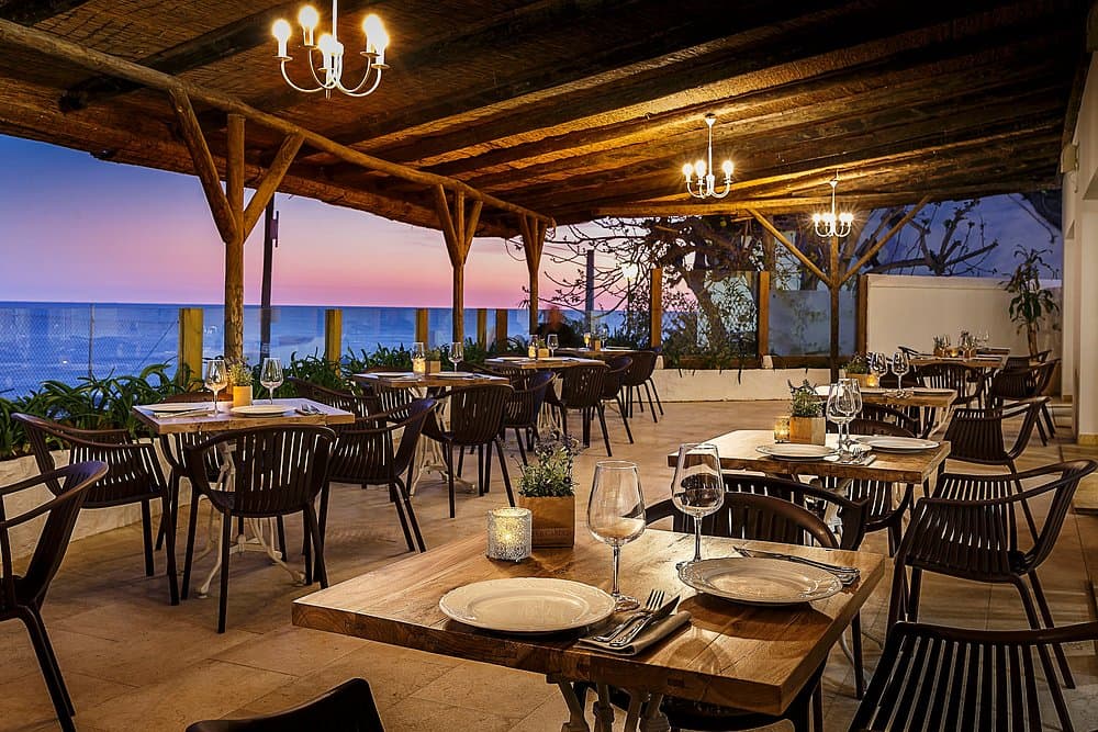 Seafront restaurant terrace in Barbate, Cádiz, tables set for dinner at sunset