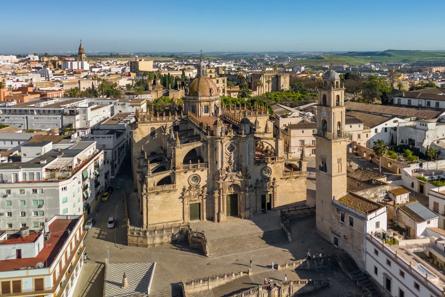 Vista aérea da Catedral de Jerez de la Frontera e do seu campanário sobre os telhados brancos do centro histórico andaluz.